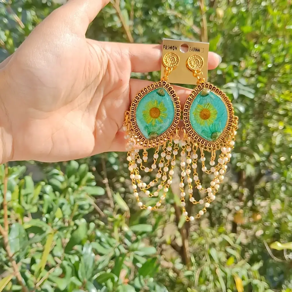 Gold framed cyan resin earring.