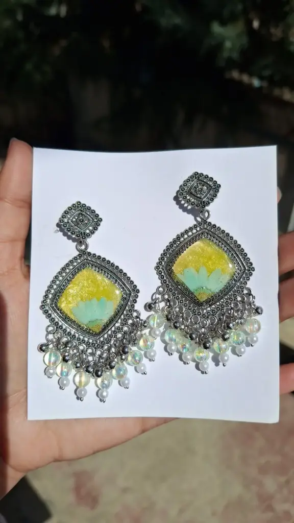 Silver framed yellow resin earring.