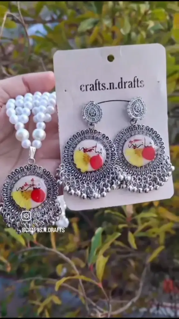 Urdu calligraphic resin earring with pendant.
